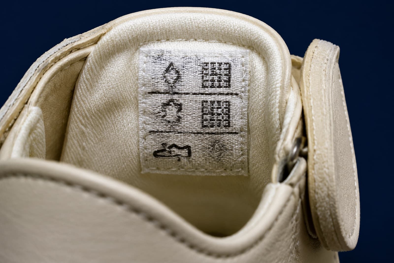 The stitched material label inside the shoe showing three rows of pictogram symbols