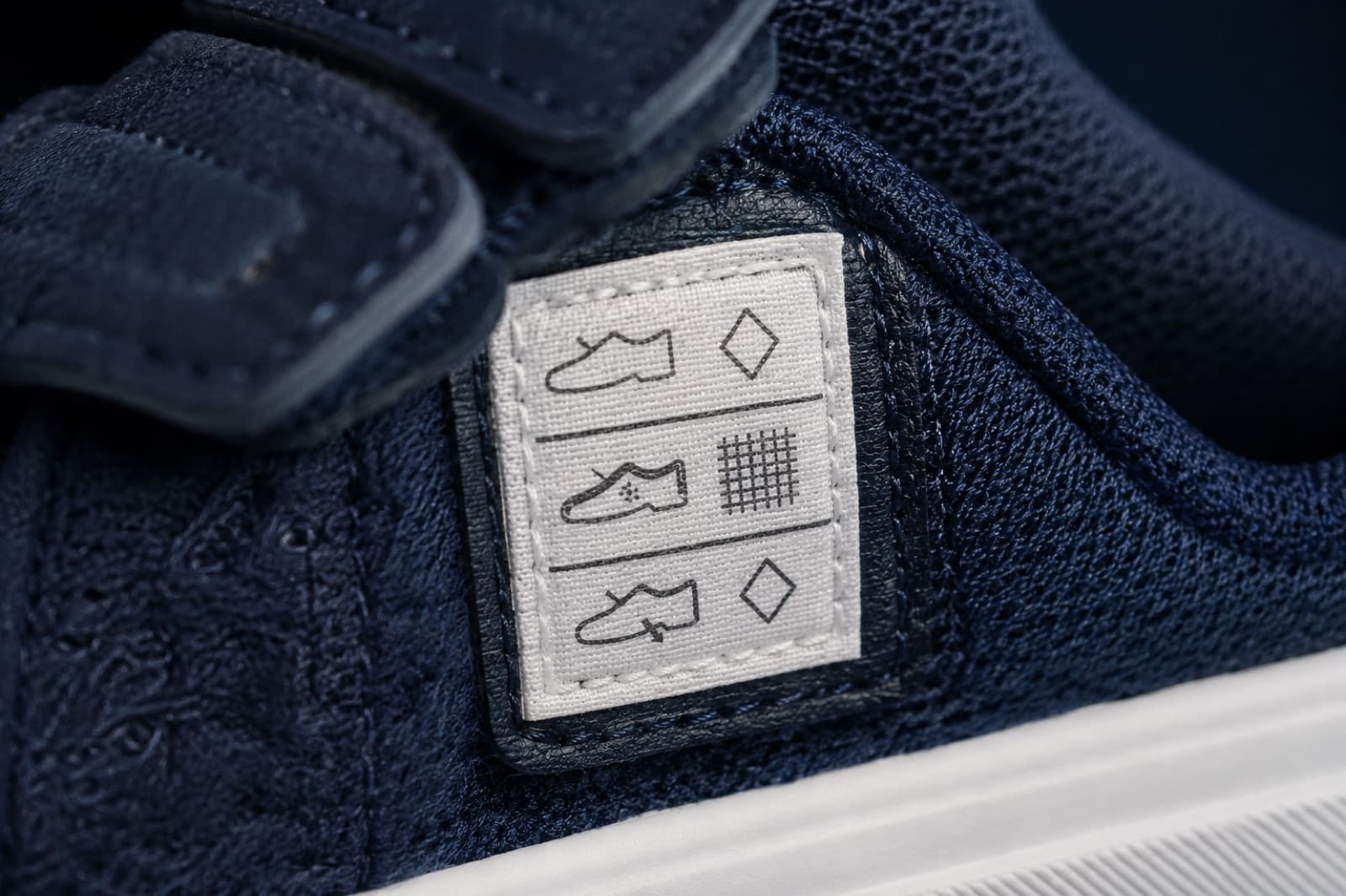 The stitched material label inside the shoe showing three rows of pictogram symbols