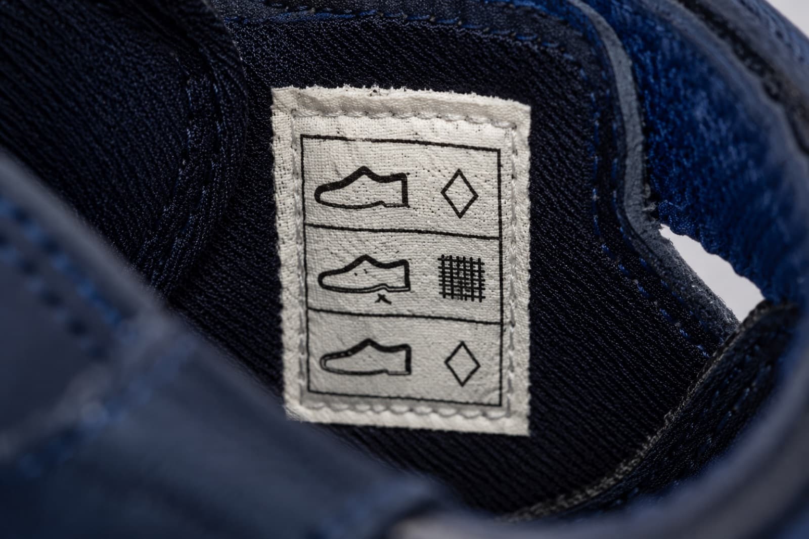 The stitched material label inside the shoe showing three rows of pictogram symbols